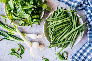 Haricots verts frais et oignons grelot sur la table de cuisine