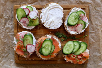 Assorted bagels with cream cheese, smoked salmon, cucumbers, radishes, dill, and olives. Breakfast...