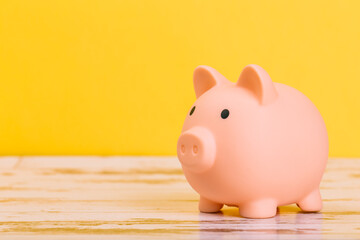 pink piggy bank on a yellow background, space for text. Finance, saving money, crisis. Business or Retirement Savings