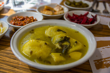 Traditional hot yellow Kubbe soup, a famous middle eastern dumplings soup dish, served in a bowl. Jerusalem, Israel. 