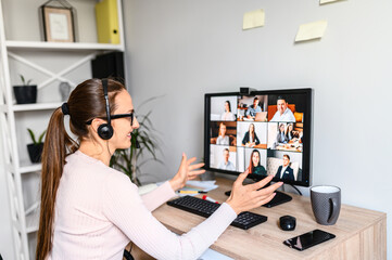 Online meeting, remote work. Young business woman with glasses using app on PC for video...