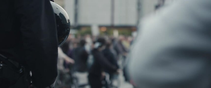 Police officer in protection riot gear helmet and gun guarding demonstrations on bicycles protest against government for protecting nature in Europe during pandemic unrecognizable