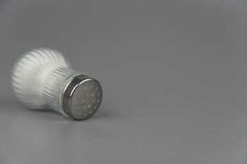 A pile of salt from salt shaker, concept excessive salt intake and white death