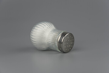 A pile of salt from salt shaker, concept excessive salt intake and white death