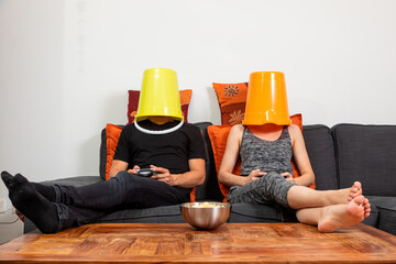 Young couple play video games sitting comfortably on the sofa at home