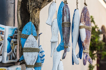 Decorative wooden fishes hanging from above at one of souvenir shops in Oia town, Santorini, Greece