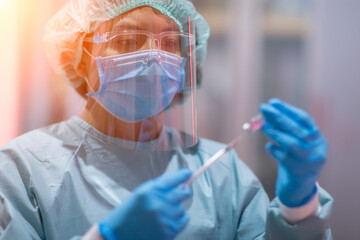 The doctor or lab technician scientist in PPE Personal Protective Equipment holding vacine test ...