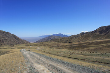 Fototapeta na wymiar Dirt road among the mountains. Kazakhstan