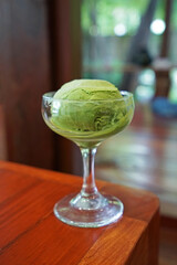 Ice cream scoop of Japanese Matcha green tea on wooden table