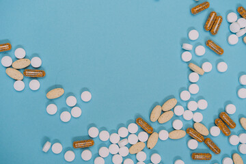many scattered Colorful medical pills on blue background. Pills are scattered over a blue background. Close up. Medical background.