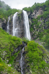 Fototapeta na wymiar View of the waterfall in Caucasian mountains