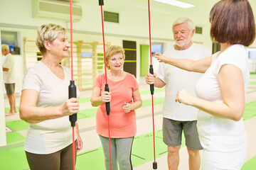 Senioren und Fitnesstrainer mit Schwingstab