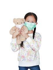 Portrait asian little child girl carry teddy bear with wearing medical protective mask together isolated on white background and looking at camera