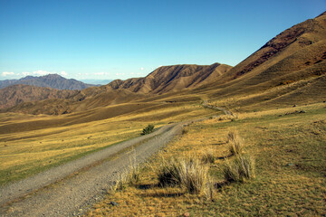Fototapeta na wymiar Dirt road among the mountains. Kazakhstan
