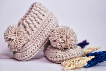Fototapeta na wymiar Small children's socks. Booties in gray on a white background. Wool socks for the baby.
