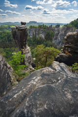 Unrecognized silhouette climber on mountain top enjoying famous Bastei rock formation of national park Saxon Switzerland, Germany. Spring season active travel adventure
