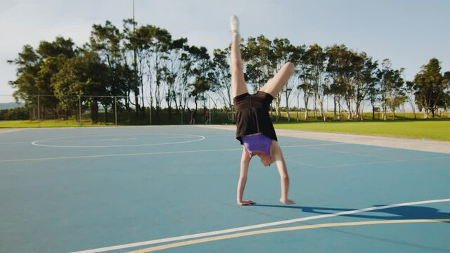Young Woman Does Bent Knee Split Handstand on Sunny Morning. Wide Shot