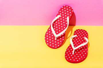 Red beach flip flops on colorful background