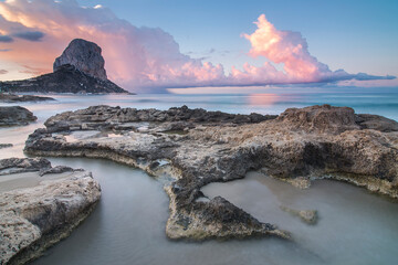 Paisaje de peñón de Ifach de Calpe, desde  los baños de la reina, con primer plano de rocas y...