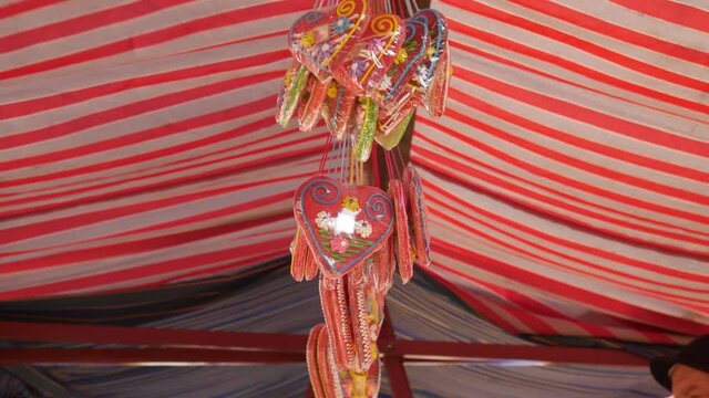 Gingerbread hearts hanging below the festivals red and white striped tent.