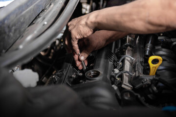 Obraz na płótnie Canvas Car mechanic working on engine repair