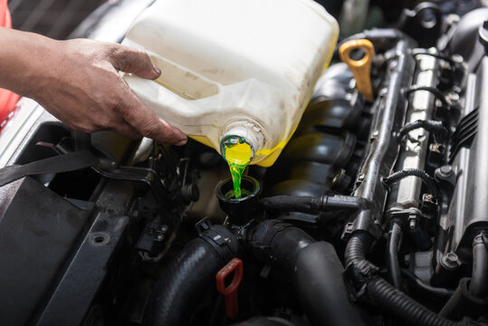 Car Mechanic Pour The Water Coolant To The Car Radiator