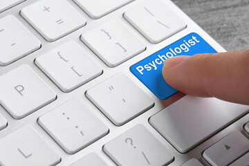 Woman pressing button with word PSYCHOLOGIST on modern computer keyboard, closeup