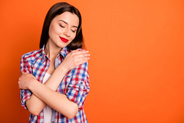 Close-up portrait of her she nice attractive lovely pretty straight-haired girl wearing checked shirt hugging herself isolated on bright vivid shine vibrant orange color background
