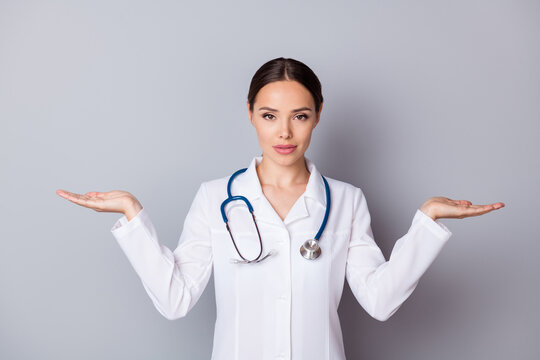 Photo of attractive doc professional hold two open palms empty space advising good quality vitamins pick select one better wear medical uniform lab coat stethoscope isolated grey background