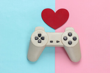 Game lover. Retro gamepad with red heart on pink blue pastel background. Retro 80s. Top view.