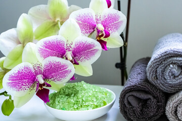 Fototapeta na wymiar Spa composition with towels, an orchid flowers snd sea salt