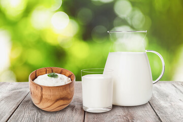 Set of different dairy products on wooden table outdoors
