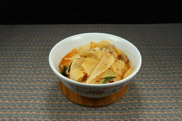 Traditional boiled spicy young bamboo shoot with basil, Thai red curry paste, chilly and coconut milk. Famous hot stew soup in Asia. High fiber with sour tasty. 