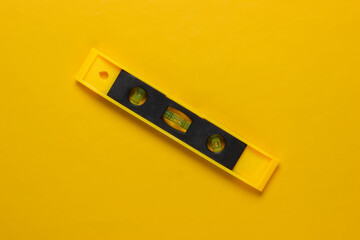 Construction level on a yellow studio background. Top view. Minimalism