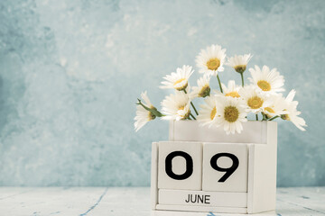 White cube calendar for june decorated with daisy flowers