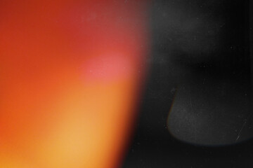 Orange light effect on black background. Abstract wallpaper. Retro film photography effect. Analog...