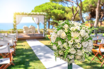 Fototapeta na wymiar Wedding ceremony on a beautiful green lawn by the ocean on a sunny day.