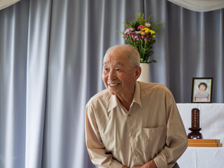 An elderly Asian man delivery a speech at a family event