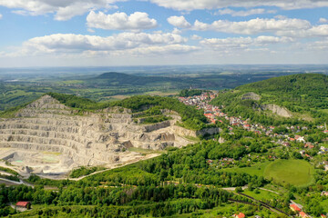 Fototapeta na wymiar Limestone quarry adjacent to the population center, aerial view. Mining industry. Strumberk czech 01 06 2020