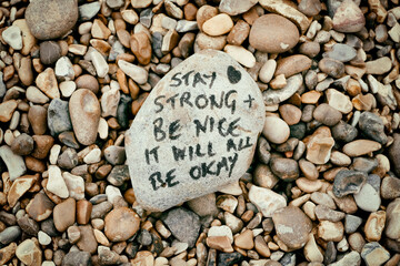 'Stay strong, be nice, it will be okay'. Positive message written on a stone on Aldeburgh Beach,...
