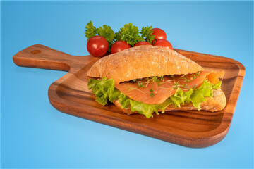 sandwich with salmon and salad on blue background