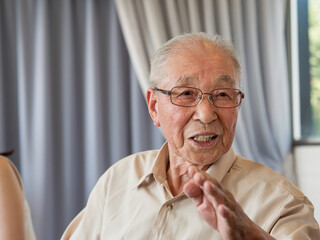 An old man talking animatedly at a family event