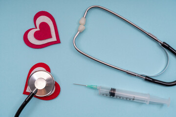 Medical tools stethoscope, syringes with a heart on a blue background.