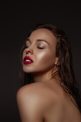 Inspired. Portrait of beautiful stylish woman isolated on dark studio background. Caucasian model with red lipstick, wet hair and shiny skin, bright make up. Beauty, fashion, emotions concept.