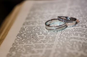 Wedding rings on lying on an open sheet of a book.