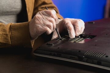 Close-up hold screwdriver to repair faulty broken computer equipment. Disassembling the CPU for parts