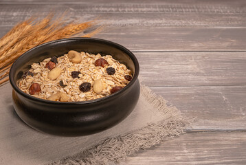 oatmeal with nuts in a mug on a wooden background