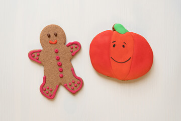 Orange pumpkin cookie on white wooden background, Halloween  handmade decoration