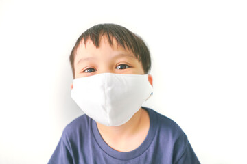 Little kid wear face mask and smiling behind the mask isolated on white background 