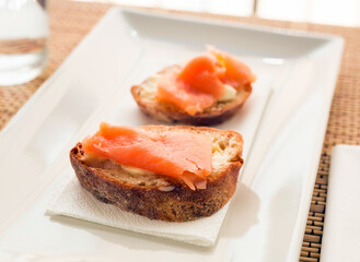 delicious canapes of salted, smoked salmon fillet on slice of fresh ciabatta bread